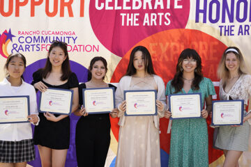 6 females standing and holding certificates in front of colorful backdrop
