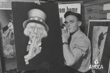 a man with his index finger at his mouth holding a painted image of Uncle Sam with finger to his mouth.